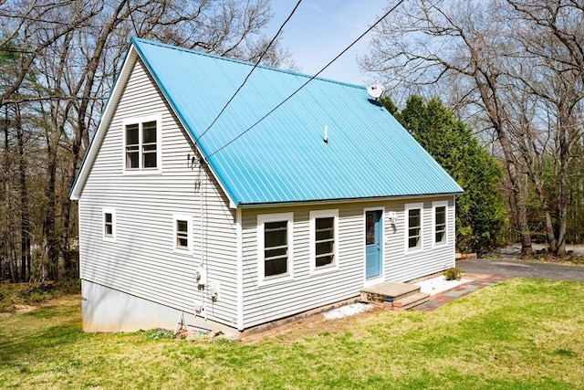 back of house with a yard and metal roof