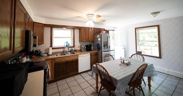 kitchen with a sink, appliances with stainless steel finishes, ceiling fan, and light tile patterned flooring