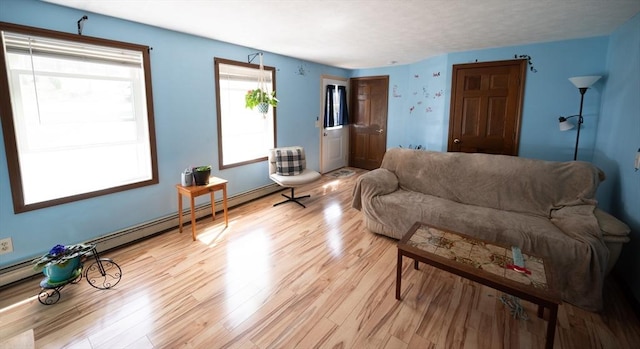 living room with a baseboard radiator and light wood finished floors