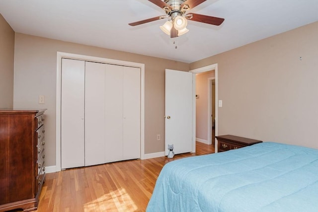 bedroom with light wood-style flooring, baseboards, a closet, and ceiling fan