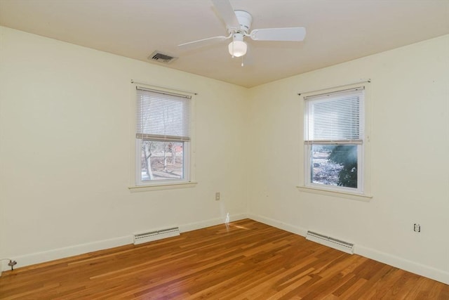 unfurnished room featuring light wood finished floors, visible vents, and baseboards