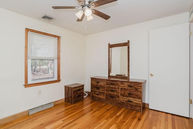 bedroom featuring visible vents, a baseboard heating unit, baseboards, light wood-type flooring, and a ceiling fan