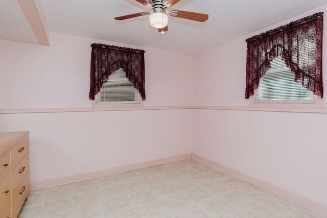 empty room featuring beam ceiling, baseboards, and ceiling fan