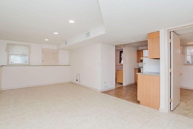 unfurnished living room featuring visible vents, recessed lighting, and baseboards