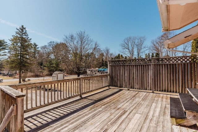 wooden deck with an outbuilding and a shed