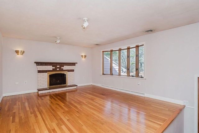 unfurnished living room featuring wood finished floors, baseboards, visible vents, a baseboard radiator, and a fireplace