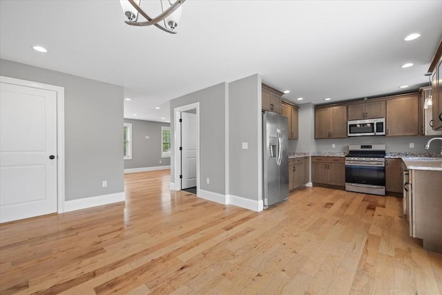 194B Narrows Rd, Westminster, MA 01473 - kitchen with stainless steel appliances, light wood finished floors, a sink, a chandelier, and recessed lighting