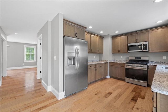 194B Narrows Rd, Westminster, MA 01473 - kitchen featuring appliances with stainless steel finishes, light wood-style floors, baseboards, light stone counters, and recessed lighting