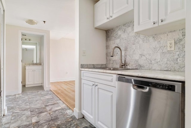 kitchen featuring dishwasher, a sink, white cabinetry, light countertops, and decorative backsplash