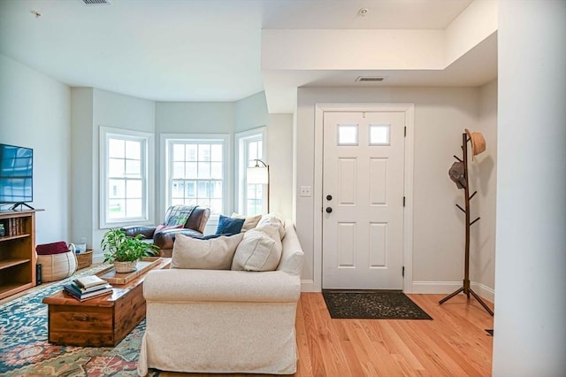 foyer entrance featuring light wood-style flooring and baseboards