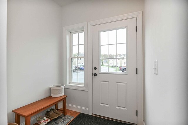 doorway to outside with light wood-style flooring and baseboards