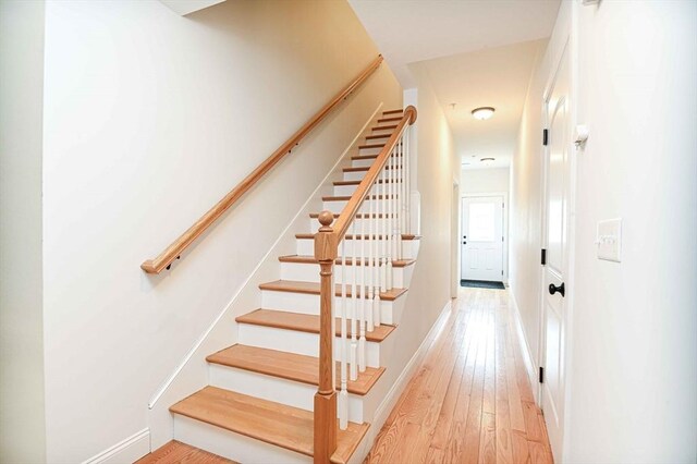 stairway featuring hardwood / wood-style floors and baseboards