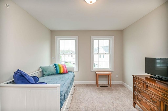 bedroom featuring light carpet and baseboards