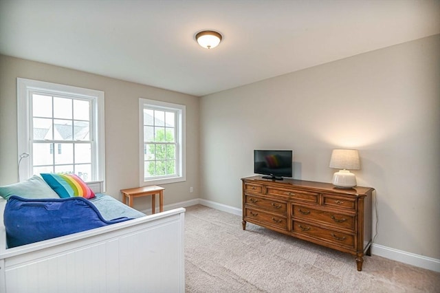 bedroom featuring baseboards and light colored carpet