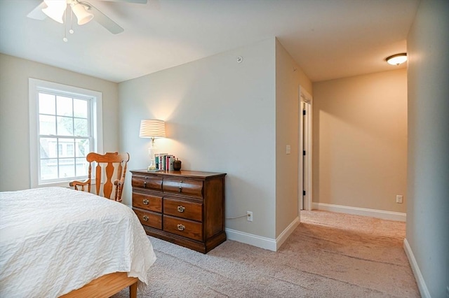 bedroom with baseboards, light carpet, and a ceiling fan