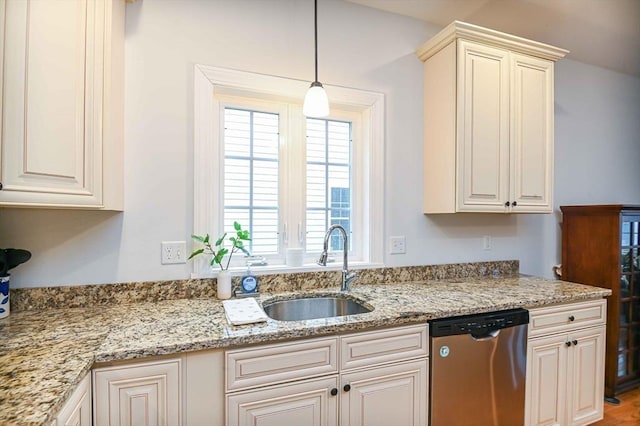 kitchen featuring stainless steel dishwasher, a sink, light stone countertops, and hanging light fixtures