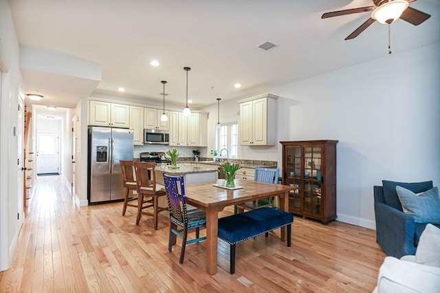 dining space with light wood-style flooring, a ceiling fan, baseboards, and recessed lighting