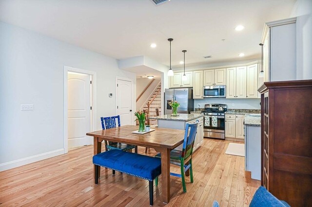 dining area featuring light wood finished floors, stairs, baseboards, and recessed lighting
