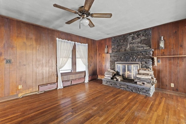 unfurnished living room featuring hardwood / wood-style floors, wood walls, and a fireplace