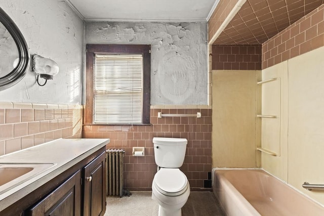 full bathroom with radiator heating unit, vanity, tile walls, toilet, and  shower combination