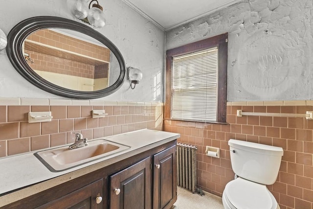 bathroom featuring radiator, toilet, tile walls, and vanity