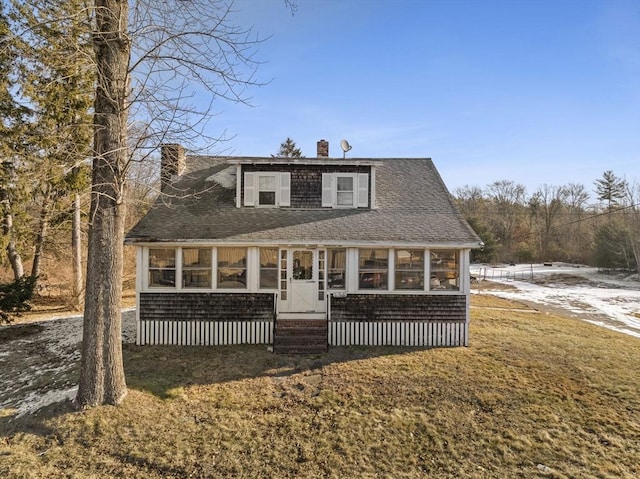 view of front of property with a front yard and a sunroom