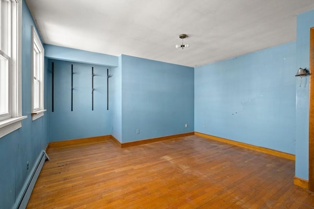 spare room with a baseboard radiator and hardwood / wood-style floors