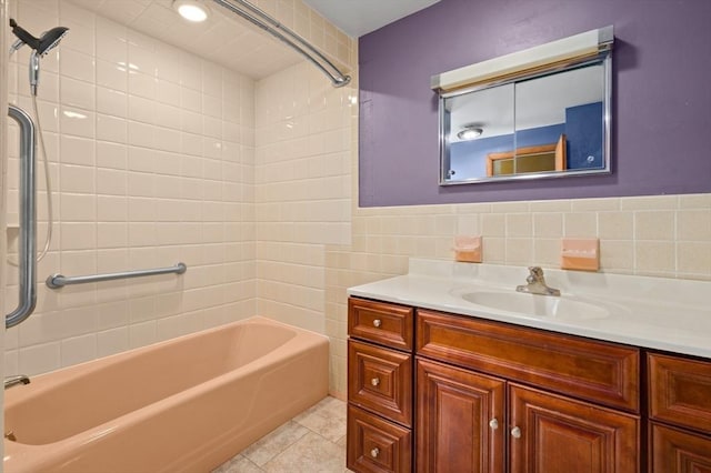 bathroom with tiled shower / bath, vanity, tile patterned flooring, and tile walls