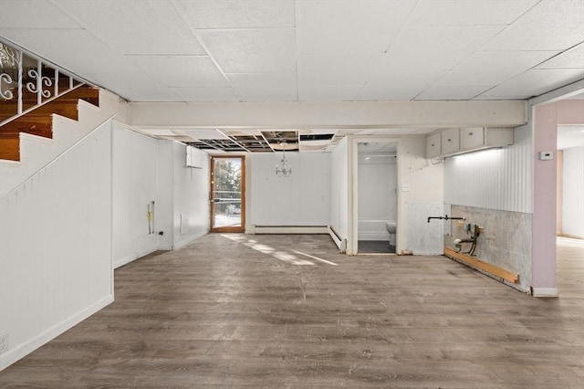 basement featuring a baseboard radiator and hardwood / wood-style floors