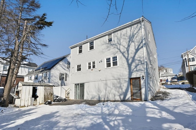 snow covered house with a storage unit