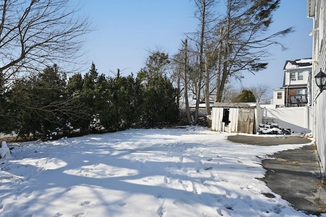 yard layered in snow featuring a storage unit