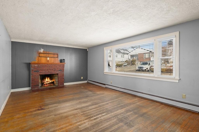 unfurnished living room with hardwood / wood-style flooring, a brick fireplace, a textured ceiling, and baseboard heating