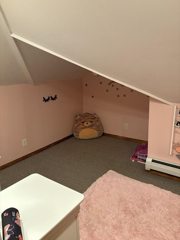 additional living space featuring baseboards, carpet, lofted ceiling, and a baseboard heating unit