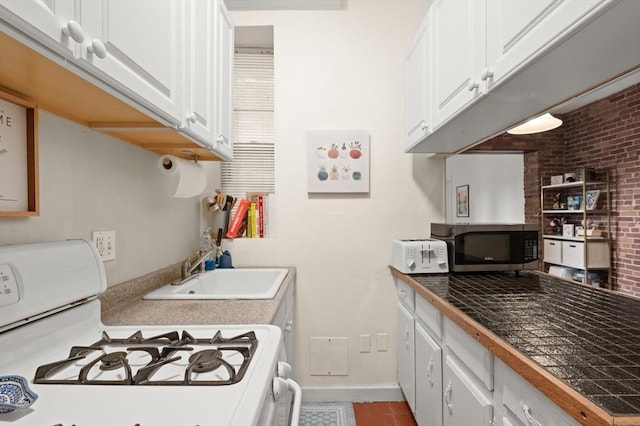 293-295 Commonwealth Ave Unit 3B, Boston, MA 02115 - kitchen featuring white range with gas cooktop, stainless steel microwave, a sink, white cabinets, and baseboards