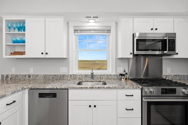 35 Liberty St, Salisbury, MA 01952 - kitchen featuring appliances with stainless steel finishes, a sink, white cabinetry, open shelves, and light stone countertops