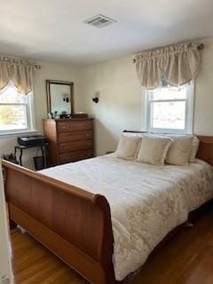 bedroom featuring visible vents and wood finished floors