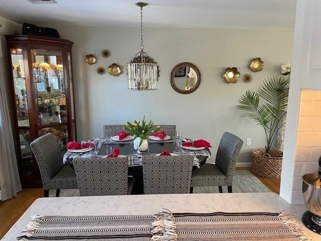 dining space with visible vents and wood finished floors