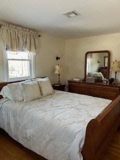 bedroom with visible vents and wood finished floors