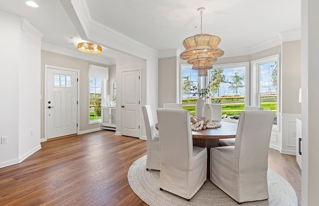 dining room with plenty of natural light, crown molding, dark wood-type flooring, and a chandelier