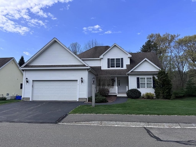 traditional-style house with a porch, a front lawn, driveway, an attached garage, and roof with shingles