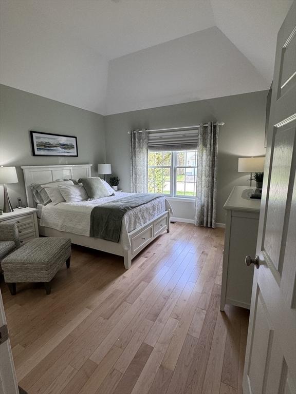 bedroom featuring light wood-type flooring and high vaulted ceiling