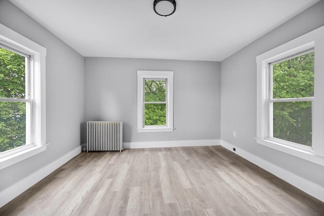 14-18 Florence St, Leominster, MA 01453 - empty room with radiator, plenty of natural light, wood finished floors, and baseboards