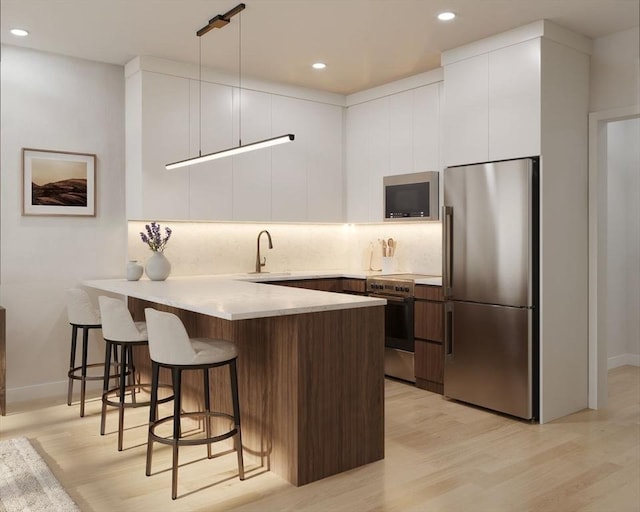 kitchen featuring tasteful backsplash, white cabinets, modern cabinets, a peninsula, and stainless steel appliances