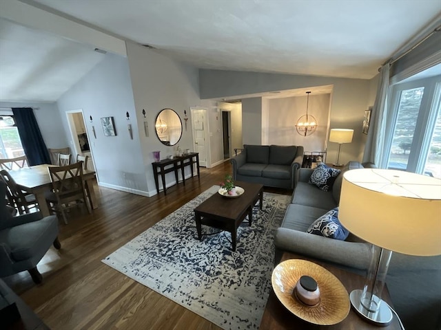 living room with vaulted ceiling, a chandelier, and dark hardwood / wood-style floors