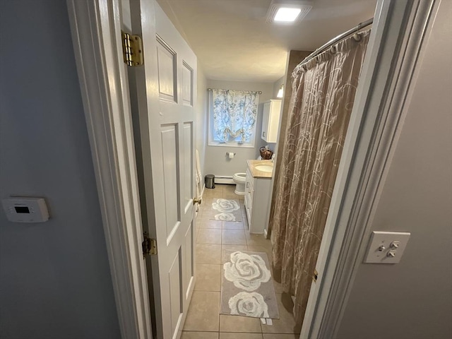 bathroom with toilet, tile patterned floors, a baseboard heating unit, and vanity