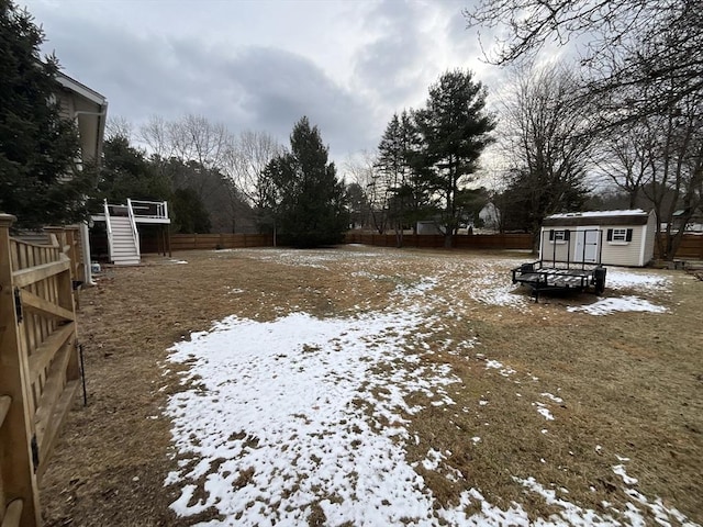 snowy yard featuring a storage shed