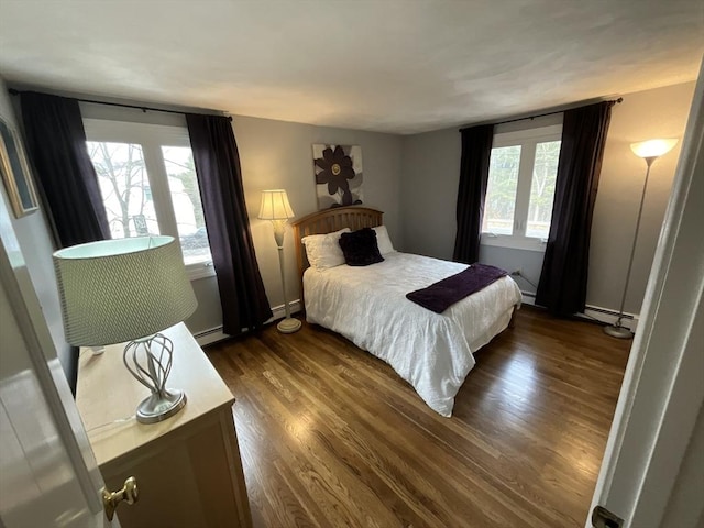 bedroom featuring dark wood-type flooring, multiple windows, and a baseboard radiator