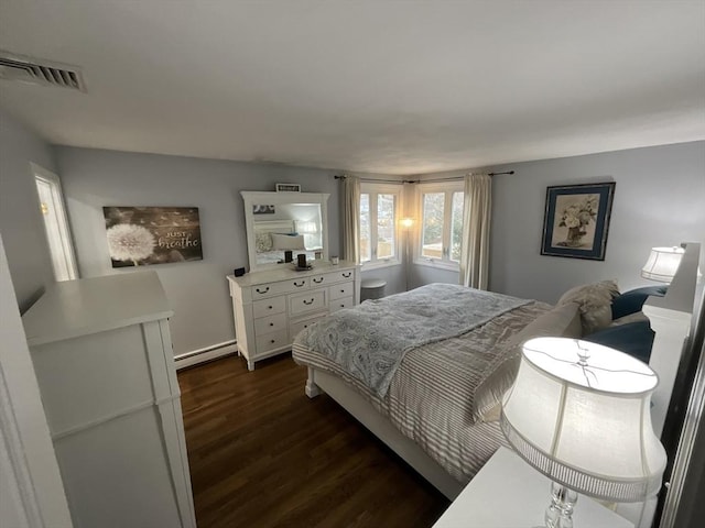 bedroom featuring baseboard heating and dark hardwood / wood-style flooring