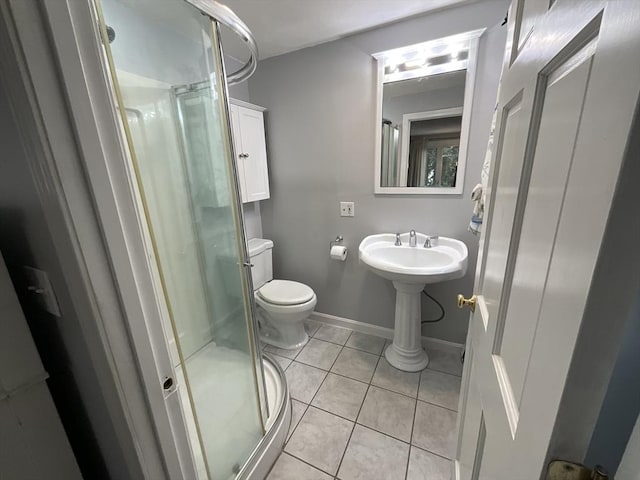 bathroom with toilet, tile patterned flooring, and a shower with door