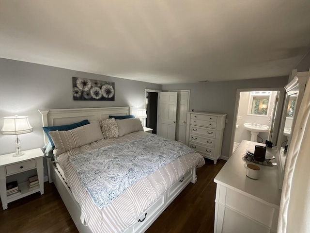 bedroom featuring ensuite bathroom and dark wood-type flooring